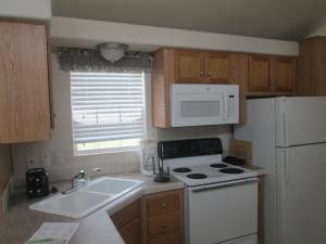 a kitchen with a white stove and a microwave at Lake Magic Park Model 15 in Kissimmee