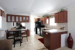 a kitchen with wooden cabinets and a table with chairs at Lake Magic Cottage 1 in Kissimmee