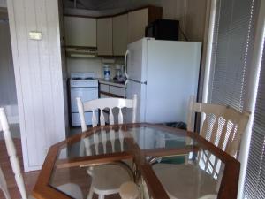 a kitchen with a table and chairs and a white refrigerator at Lake Myers Lakeside Villa 16 in Mocksville