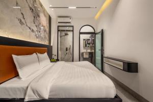 a bedroom with a large white bed and a shower at Mai Villa - My Khe Beach in Da Nang