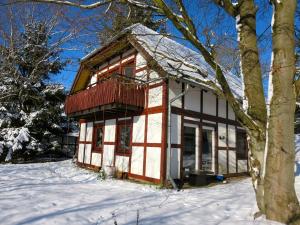 a small house with a balcony in the snow at Natururlaub Frankenau in Frankenau