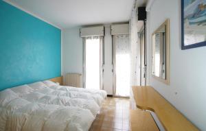 a bedroom with a white bed and blue walls at 2 Bedroom Lovely Apartment In Lavagna in Lavagna