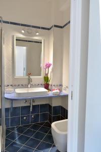W łazience znajduje się umywalka, toaleta i lustro. w obiekcie Acquamarine Maiori Amalfi Coast w mieście Maiori