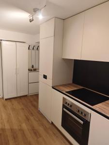 a kitchen with white cabinets and a stove top oven at Ruhige FeWo Soutterainwohnung im Grünen in Hamburg
