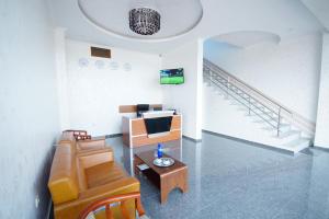 a living room with a couch and a tv and stairs at Hotel 725 in Batumi