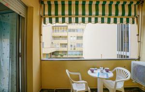 a table and chairs in a room with a large window at 2 Bedroom Lovely Apartment In Lavagna in Lavagna +6 photos