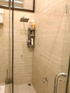 a shower with a glass door in a bathroom at Azzahra Homestay in Permatang Pauh +8 photos