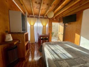 a bedroom with a bed and a flat screen tv at Hermoso departamento en Playa Hermosa Pichilemu - Cabañas Parova in Pichilemu