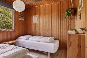 a room with two beds in a wooden room at Ideal Holiday Home For Nature And Peace in Gørlev