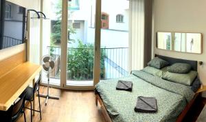 Un dormitorio pequeño con una cama y un balcón. en Quiet Central Stay & Parking Assistance, en Praga 39 fotos más