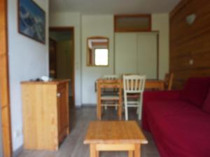 a living room with a red couch and a table at Appartement 6 pers, 2 ch, proche pistes et commerces - FR-1-807-123 in Saint-François-Longchamp