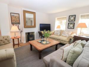 una sala de estar con un sofá y una mesa en Fairview Cottage, en Burford