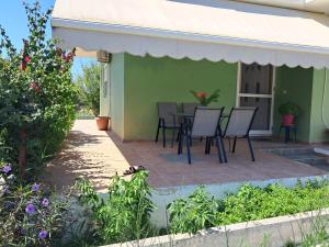 帕拉代西翁Galinis Rooms的温室里有一张桌子和椅子的露台