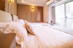 Dos camas blancas en una habitación con ventana. en 三ノ輪 吉原, en Tokio