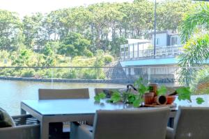a table and chairs on a balcony with a view of the water at Waterfront Stay at Sunshine Villa in Maroochydore