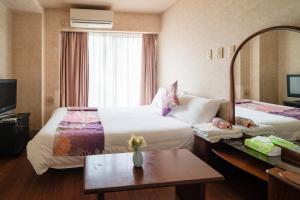 Una habitación de hotel con dos camas y un espejo. en 三ノ輪 吉原, en Tokio 123 fotos más