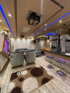 a living room with couches and a tv and a kitchen at شقه فندقيهTv75-PS4حدايق الاهراماتPyramids in ‘Ezbet `Abd el-Ḥamîd