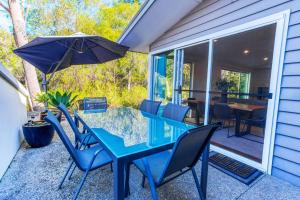 a blue table with chairs and an umbrella on a patio at Kiali 3 Cape Villas Dunsborough in Dunsborough
