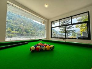 a room with a pool table with balls on it at Euphoric Resort ,Mohanchatti in Rishīkesh