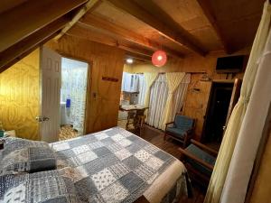 a bedroom with a bed and a table in a room at Hermoso departamento en sector Playa Hermosa Pichilemu - Cabañas Parova in Pichilemu