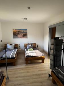 Dos camas en una habitación con suelo de madera. en Ferienwohnung Distelkamp, en Neuwied