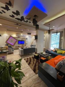 a large living room with a couch and a tv at pyramids in ‘Ezbet `Abd el-Ḥamîd