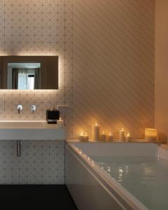 bagno con vasca, candele e specchio di Fra le righe - arte , design e interni siciliani a Catania