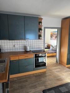 cocina con armarios azules y fogones en Ferienwohnung Distelkamp, en Neuwied