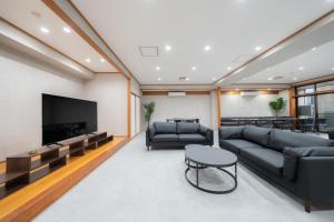 a living room with couches and a flat screen tv at Casa G,S, - Vacation STAY 93709v in Osaka