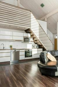 a living room with a black couch and a staircase at Spacious Mountain Cabin With Jacuzzi In Kläppen in Transtrand