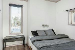 a white bedroom with a bed and a window at Spacious Mountain Cabin With Jacuzzi In Kläppen in Transtrand