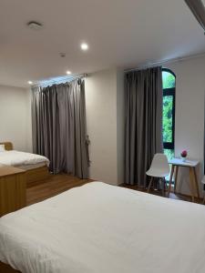 une chambre avec deux lits et une fenêtre dans l'établissement Homestay Ocean City, Kinh Đô 5-15, à Ðình Loan