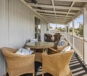 a patio with wicker chairs and a table on a porch at Hamptons in Lancelin