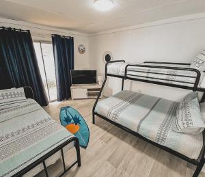 a room with two bunk beds and a flat screen tv at Hamptons in Lancelin