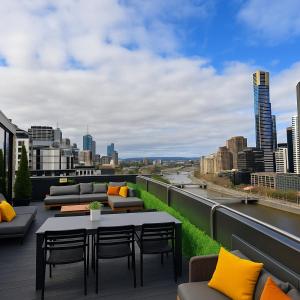 patio con divani e tavolo sul tetto di Aura on Flinders Serviced Apartments a Melbourne