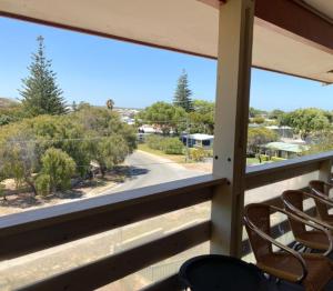 a balcony with two chairs and a view of a street at Double View in Lancelin