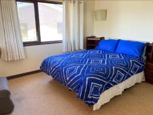 a bedroom with a blue bed and a window at Double View in Lancelin