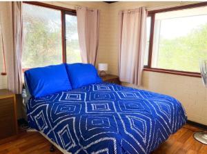 a bedroom with a blue bed and two windows at Double View in Lancelin
