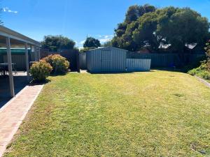 a yard with a fence and a grassy yard at Lancelin Beach house in Lancelin +3 photos