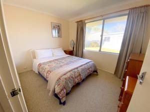 a bedroom with a bed and a large window at Lancelin Beach house in Lancelin