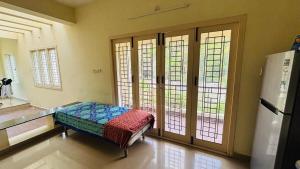 Habitación con cama en habitación con ventanas en A2C homestay in Pondicherry, en Auroville
