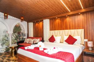 a bedroom with a large bed with red and white pillows at Le Karaj Meadows in Lovedale