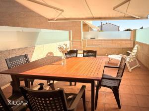 a wooden table and chairs on a patio at Xilgar - O Vimbieiro Chalet in Sanxenxo