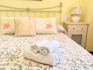 a bedroom with a bed with towels on it at Xilgar - O Vimbieiro Chalet in Sanxenxo +17 photos