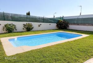 a swimming pool in the grass next to a fence at Xilgar - O Vimbieiro Chalet in Sanxenxo