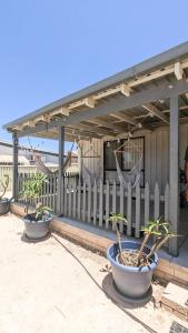 two potted plants sitting in front of a fence at Ocean Spray in Lancelin