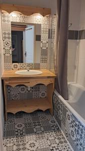 Un baño con lavabo, espejo y bañera. en Appartement cosy vue panoramique Orelle les 3 Vallées, en Orelle