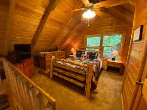 una camera con un letto in una baita di tronchi di Cozy Haven - Mountain View, Hot Tub, Fire Pit a Blue Ridge Altre 28 foto