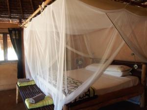 a bed with a net in a room at Ulala Lodge in Murrébuè