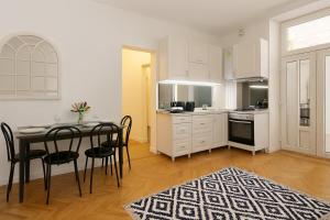 a kitchen and dining room with a table and chairs at Mid Ultra Central Apartments, Self Check In in Oradea